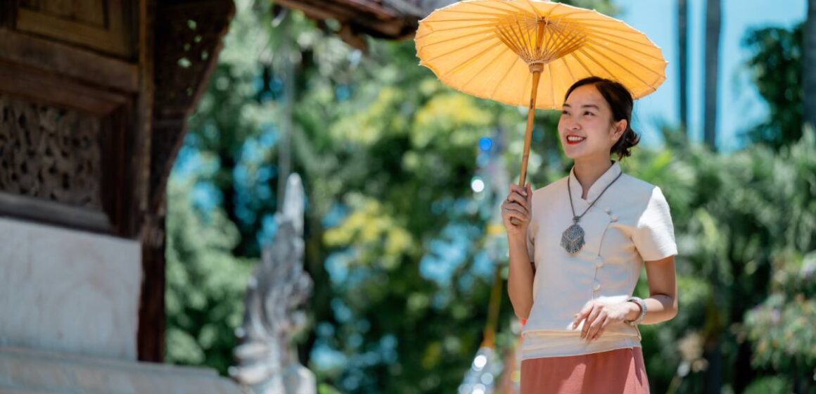 beautiful-thai-woman-holding-traditional-umbrella-2025-10-26-16-19-25-utc (1) ปีใหม่ 2568 เที่ยวไหนดี? รวม 10 จุดเช็กอินยอดนิยมต้อนรับปีใหม่