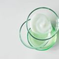 Glass petri dishes with various cosmetic products on white background, copy space. Shampoo, hair conditioner or mask and shower gel, above